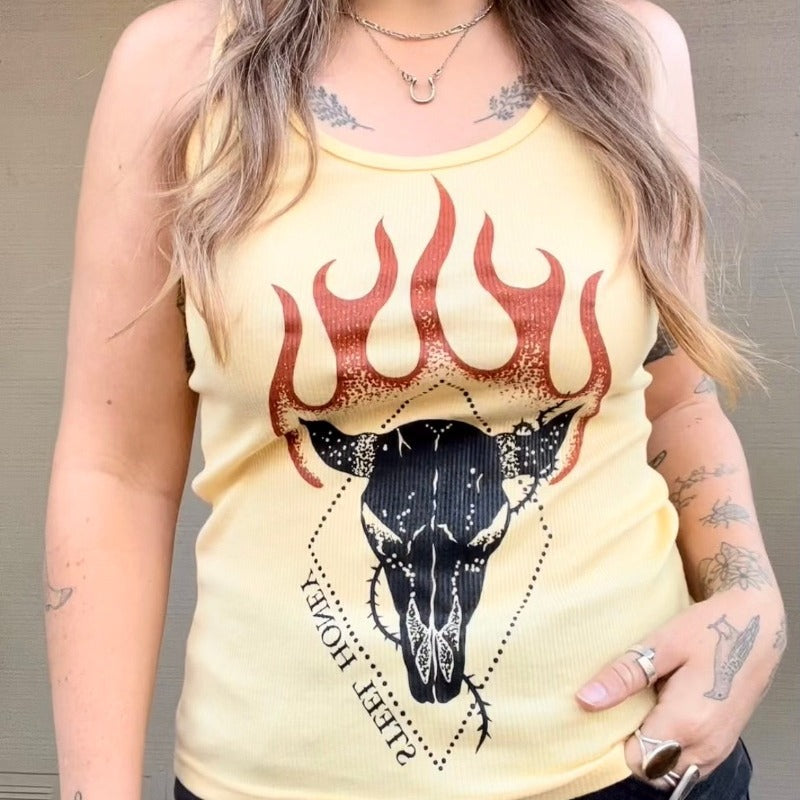 cropped image of model wearing a yellow tank top, the steel honey logo design is front and center. Black with orange flames